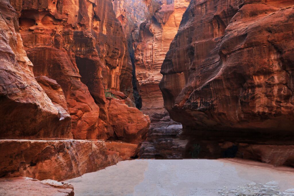 Explore the stunning sandstone canyon of Siq leading to Petra's iconic landmarks in Jordan.